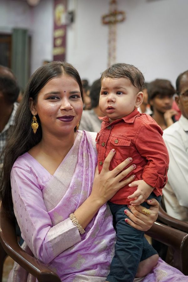 A mother holding her son in the congregation