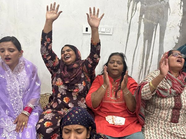 Women praying with their hands raised at the Saturday fasting prayer