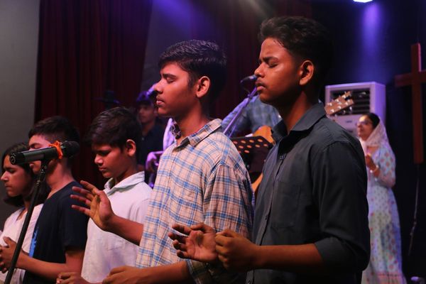 A teenage boy worshipping with his hands open