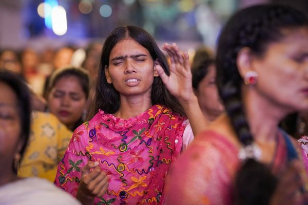 A young woman worshipping with her eyes closed